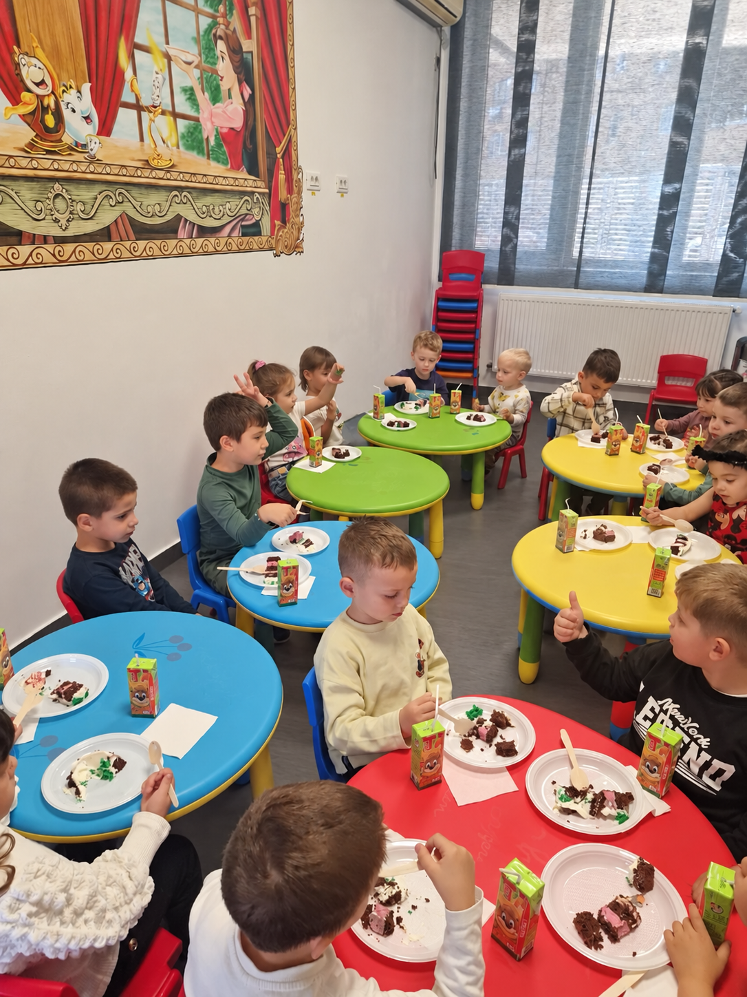 Copiii iau masa împreună la grădiniță